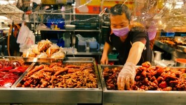 Happy traveler enjoying local street food, representing authentic and affordable travel experiences in the cheapest countries to explore.