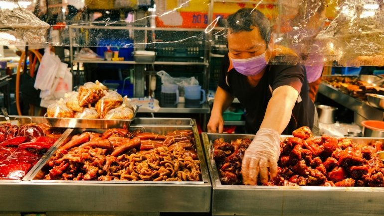 Happy traveler enjoying local street food, representing authentic and affordable travel experiences in the cheapest countries to explore.