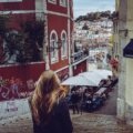 A stylish young traveler exploring a narrow cobblestone street in one of Europe's coolest cities, with historic buildings and vibrant street art in the background, representing a unique European adventure.