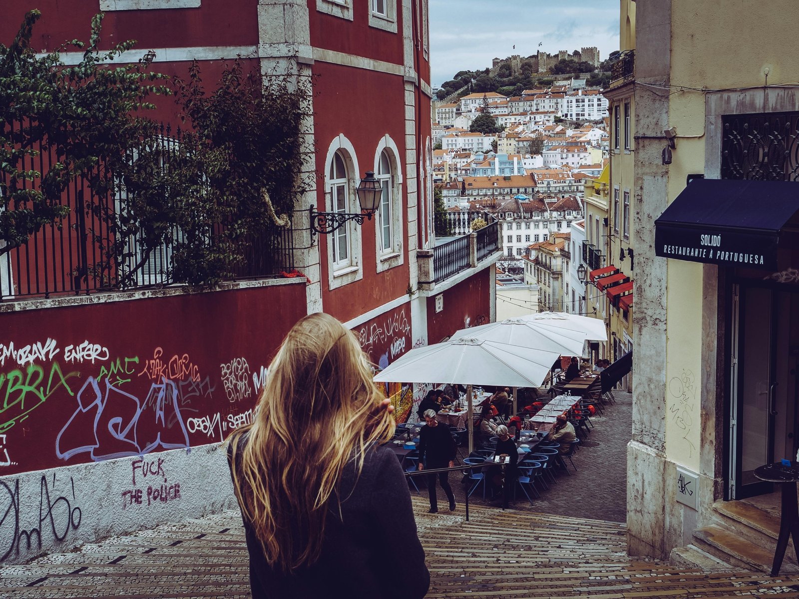A stylish young traveler exploring a narrow cobblestone street in one of Europe's coolest cities, with historic buildings and vibrant street art in the background, representing a unique European adventure.