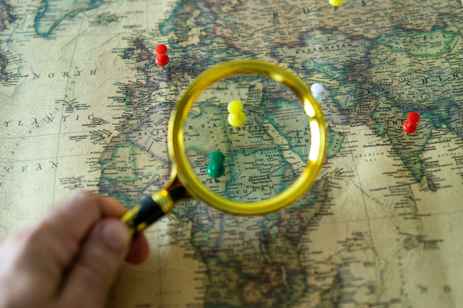 Hands interacting with a personalized traveler map, marking destinations and drawing routes for an upcoming adventure, blending digital and traditional planning tools.