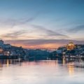 A scenic view of the colorful, historic houses of the Ribeira District along the Douro River in Porto, a highlight of the best things to do in Portugal.