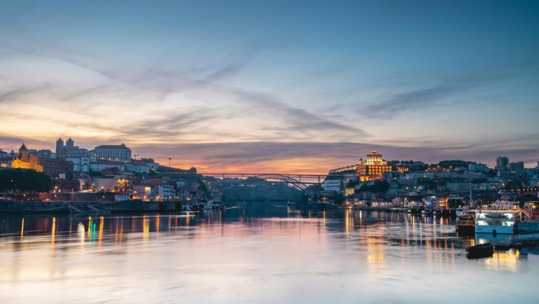 A scenic view of the colorful, historic houses of the Ribeira District along the Douro River in Porto, a highlight of the best things to do in Portugal.