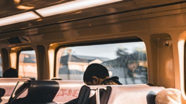 A person enjoying a budget-friendly trip across town on a bus, an example of how to save money for local city exploration.