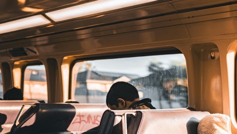 A person enjoying a budget-friendly trip across town on a bus, an example of how to save money for local city exploration.