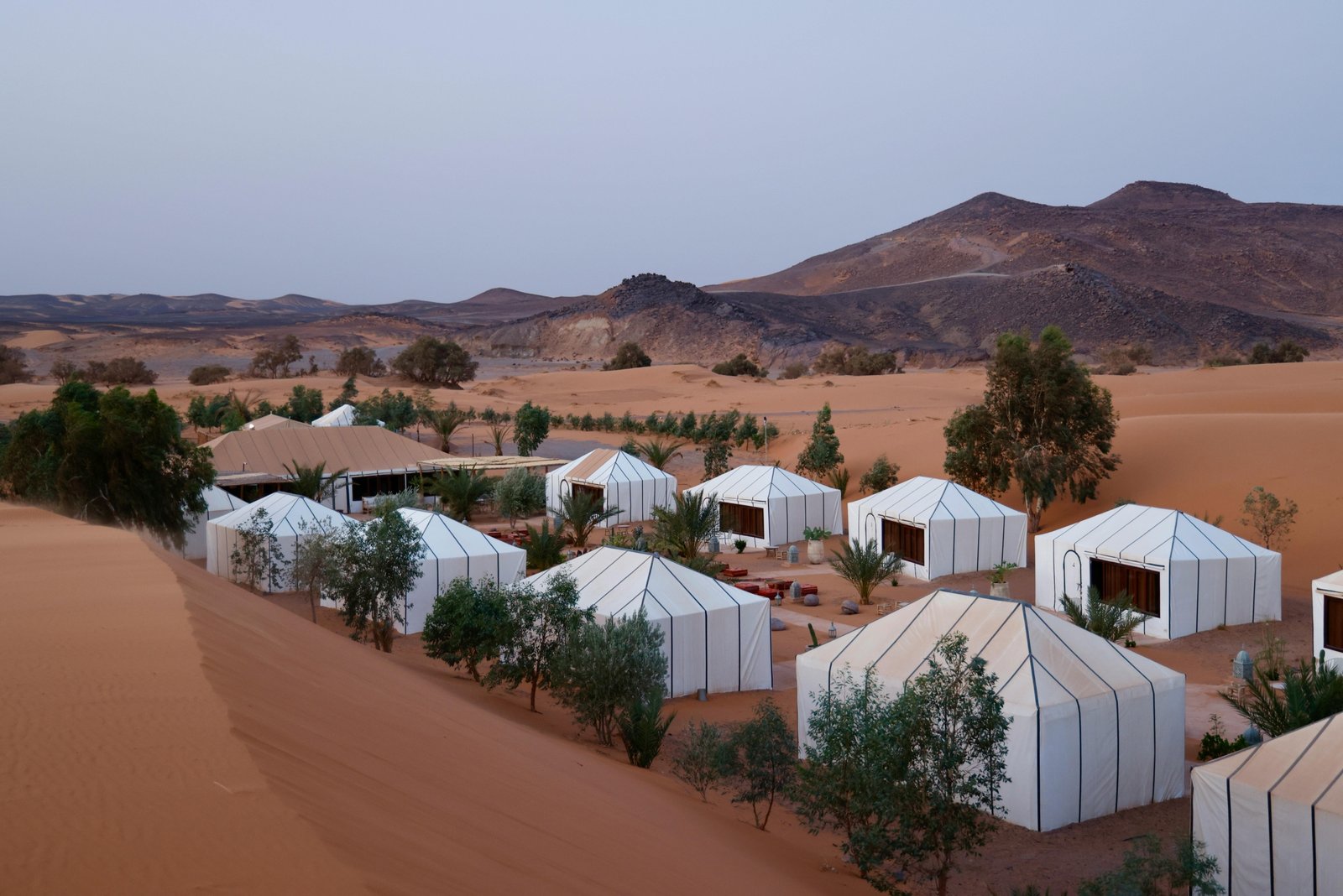 Luxury glamping tent in the rocky Agafay Desert at sunset, perfect for Marrakech desert tours and camel rides.