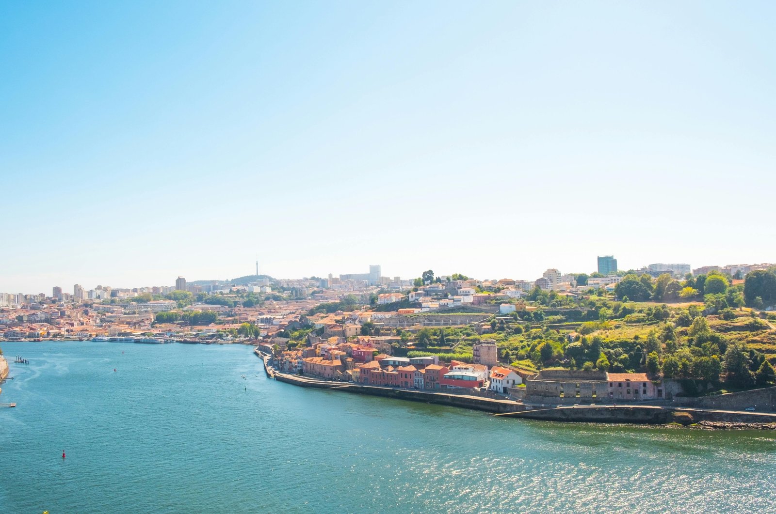 A sunny view of the stunning cliffs and turquoise water of the Algarve coast, illustrating one of the beautiful destinations to consider when deciding the best time to visit Portugal.