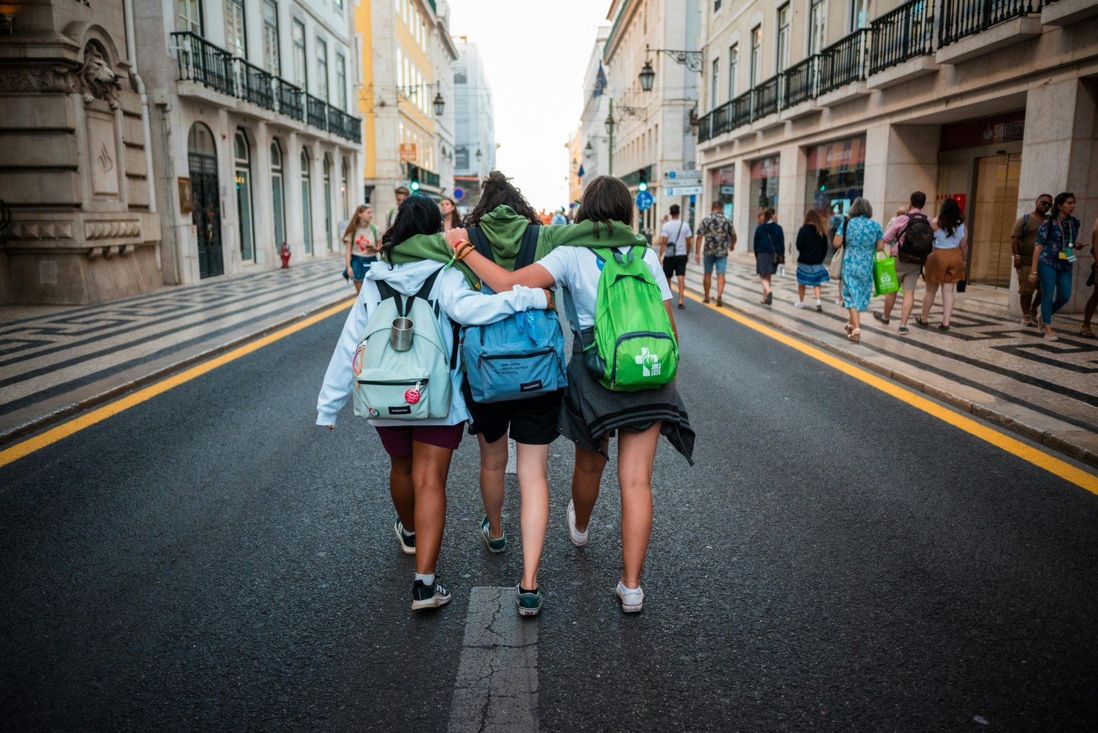 Young backpacker happily exploring a cobblestone street in a historic city, an example of an authentic and affordable low cost getaway.