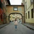 Italy travel tips for first-timers: A traveler enjoys a historic Italian street, embracing local culture and smart planning for a memorable trip.