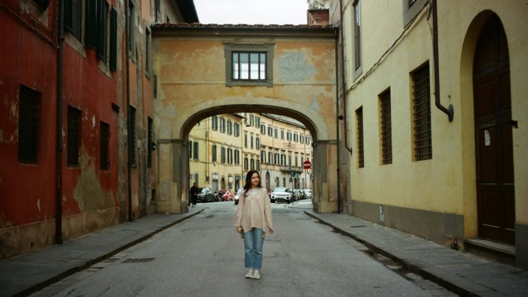 Italy travel tips for first-timers: A traveler enjoys a historic Italian street, embracing local culture and smart planning for a memorable trip.