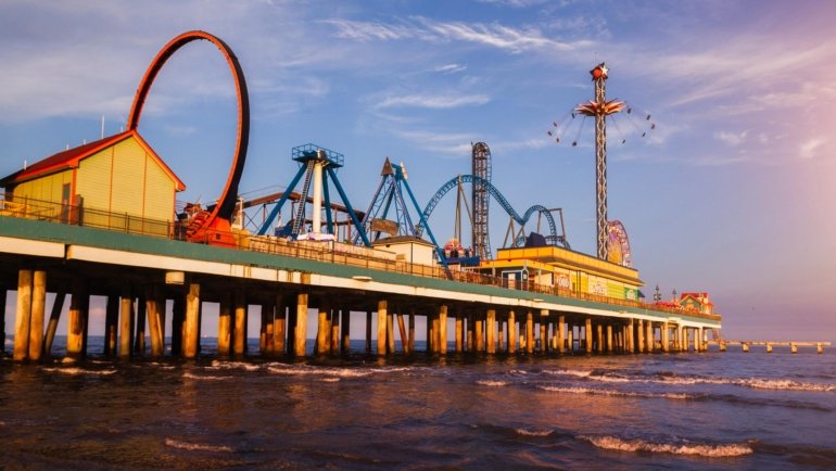 The illuminated Ferris wheel on Morey's Piers at sunset, one of the most exciting things to do in Wildwood NJ, viewed from the boardwalk.