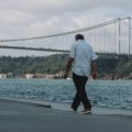 Man in versatile men's travel pants exploring a mixed urban and natural landscape, highlighting comfort, durability, and style for adventure travel and city exploration.