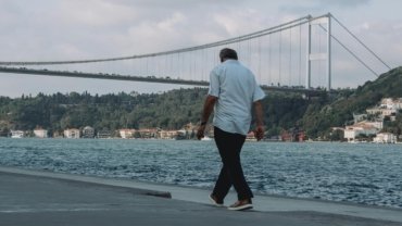 Man in versatile men's travel pants exploring a mixed urban and natural landscape, highlighting comfort, durability, and style for adventure travel and city exploration.