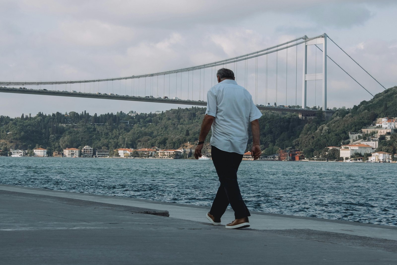 Man in versatile men's travel pants exploring a mixed urban and natural landscape, highlighting comfort, durability, and style for adventure travel and city exploration.