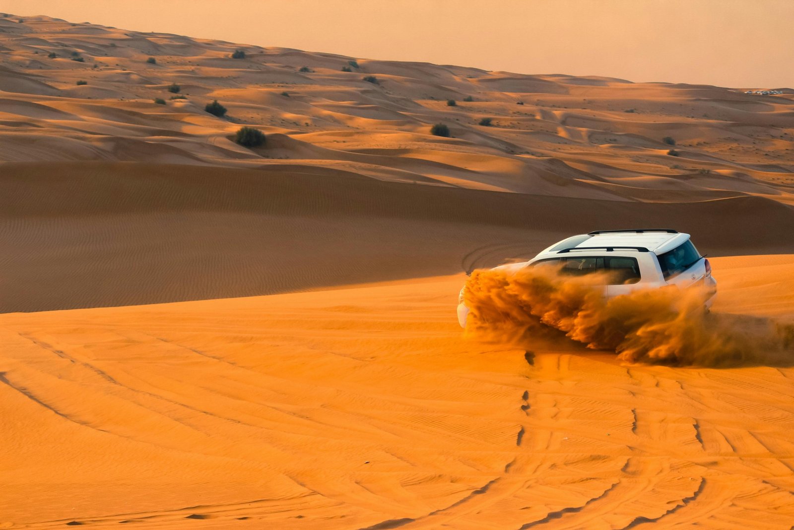 Evening desert safari Dubai experience with a camel ride on golden dunes at sunset, highlighting the adventure and cultural immersion.
