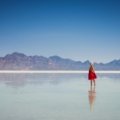 A solo female traveler stands on a viewpoint looking out over a scenic American mountain range, illustrating a safe and empowering trip to one of the best places to travel solo female in the US.