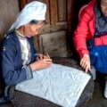 A traveler learning a traditional craft from a local artisan, an example of an authentic and unique cultural immersion experience.