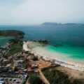 An aerial view of the stunning white sand beaches and turquoise waters of South Padre Island on a sunny day, showcasing a top destination for a Texas coastal getaway.