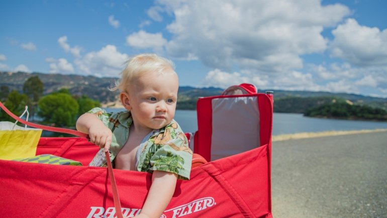 Best travel cot for baby: happy family on vacation with baby sleeping safely in a portable crib for comfortable travel.
