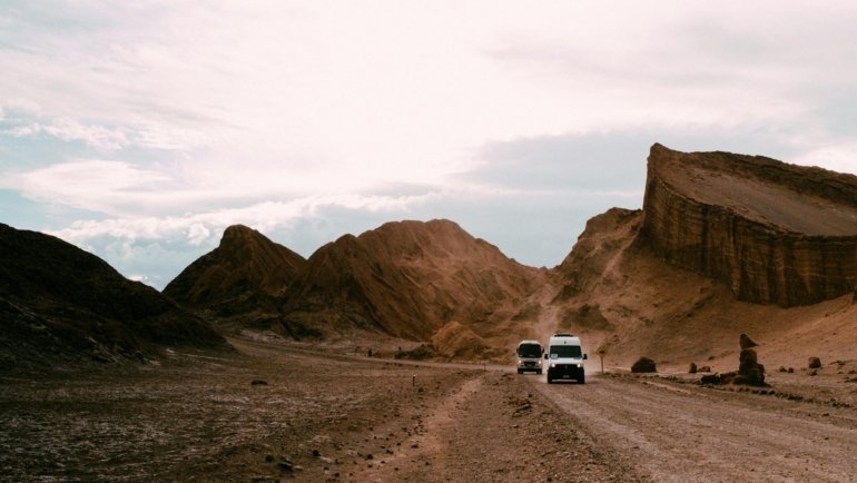 A spectacular sunset paints the otherworldly landscape of the Valle de la Luna in vibrant reds and oranges, a must-see stop on Atacama Desert Chile tours.