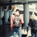 Happy backpacker exploring a vibrant budget-friendly city street, symbolizing affordable travel and smart backpacking tips.