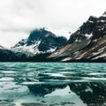 Majestic landscape of Glacier National Park with towering mountains and a serene lake, featuring hikers enjoying a stress-free, guided tour, symbolizing the benefits of a travel agency.