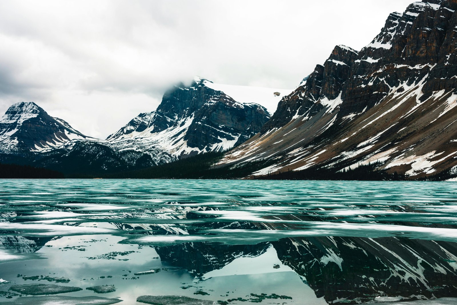 Majestic landscape of Glacier National Park with towering mountains and a serene lake, featuring hikers enjoying a stress-free, guided tour, symbolizing the benefits of a travel agency.