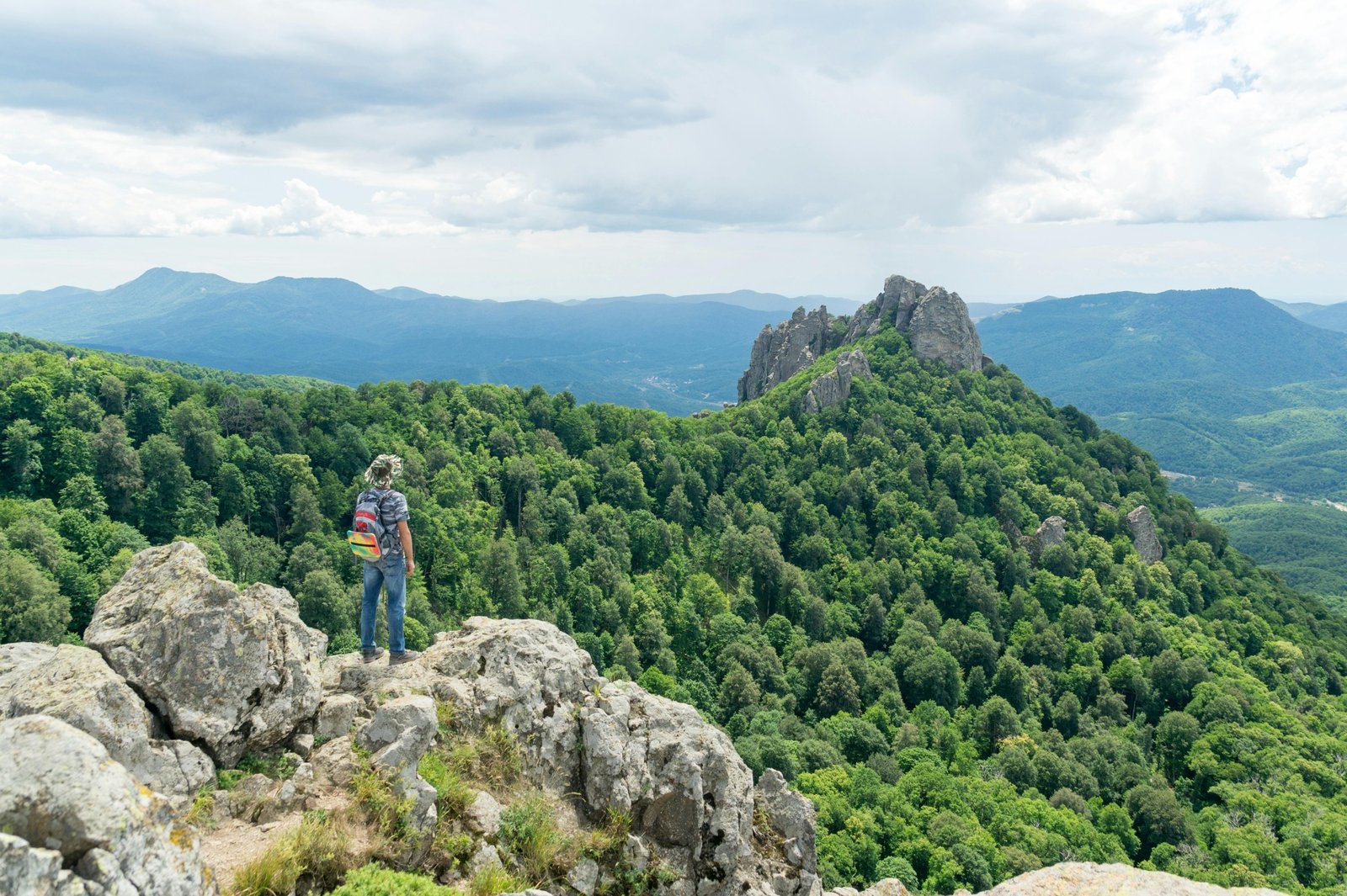 Solo traveler stands in a beautiful natural landscape, embodying the freedom, safety, and enriching discovery of solo holiday packages.