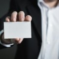 A professional individual holding a UofL travel card, symbolizing efficient university business travel expense management for faculty and staff.