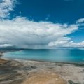 A stunning montage of diverse natural landscapes, including a mountain, beach, and forest, illustrating a tier list guide for choosing the perfect travel destination.