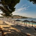 A collage showcasing the best countries to travel to in December, contrasting a sunny tropical beach with a magical snow-covered village at Christmas.