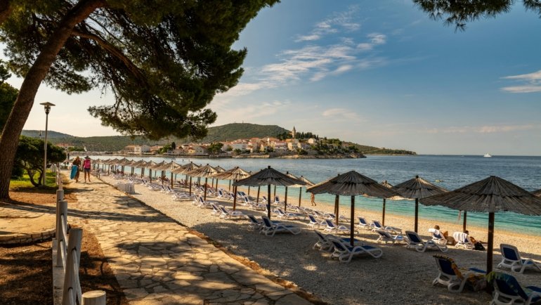 A collage showcasing the best countries to travel to in December, contrasting a sunny tropical beach with a magical snow-covered village at Christmas.