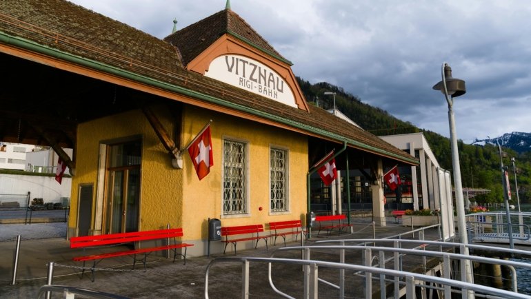 Panoramic view of a scenic Swiss travel package destination, featuring majestic Alps, a tranquil lake, a charming village, and an iconic train, highlighting diverse and convenient exploration.