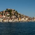 A traveler looking out over a beautiful coastal village, an example of one of the best holiday places in Europe for a 2025 vacation.