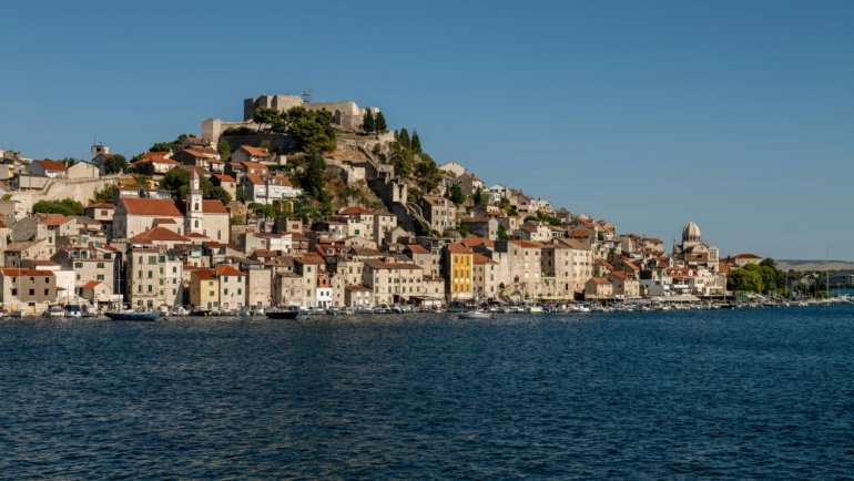 A traveler looking out over a beautiful coastal village, an example of one of the best holiday places in Europe for a 2025 vacation.