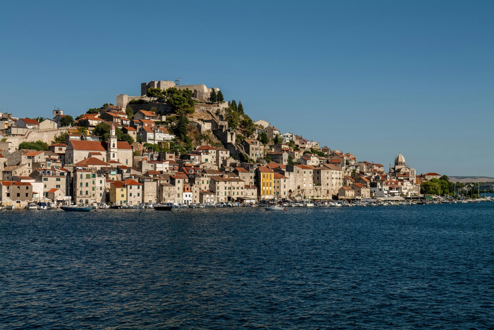 A traveler looking out over a beautiful coastal village, an example of one of the best holiday places in Europe for a 2025 vacation.