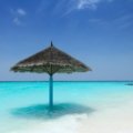 A stunning, sunny view of the pristine white sand beach and clear turquoise waters of South Padre Island, TX, the perfect destination for a 2025 beach getaway.