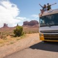 A car driving down a scenic highway in the American West, illustrating one of the most affordable places to travel in the US on a budget-friendly road trip.