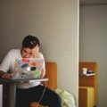 A stressed person looking at a non-functional computer, representing the start of a Tripp Lite insurance claim process for equipment damaged by a power surge.