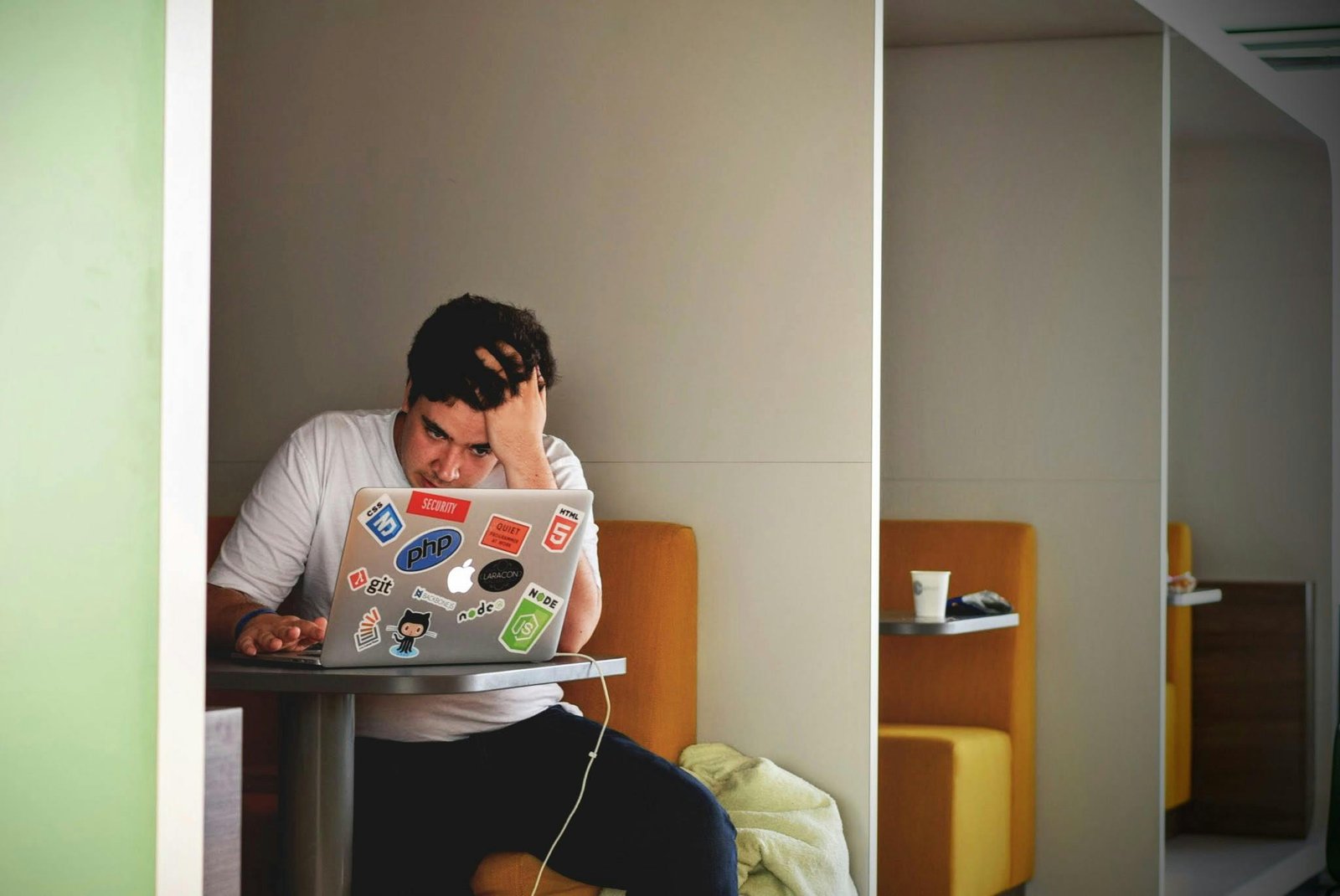 A stressed person looking at a non-functional computer, representing the start of a Tripp Lite insurance claim process for equipment damaged by a power surge.