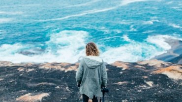 Confident woman on a solo travel adventure in a beautiful natural landscape, representing empowerment and freedom for female travelers.