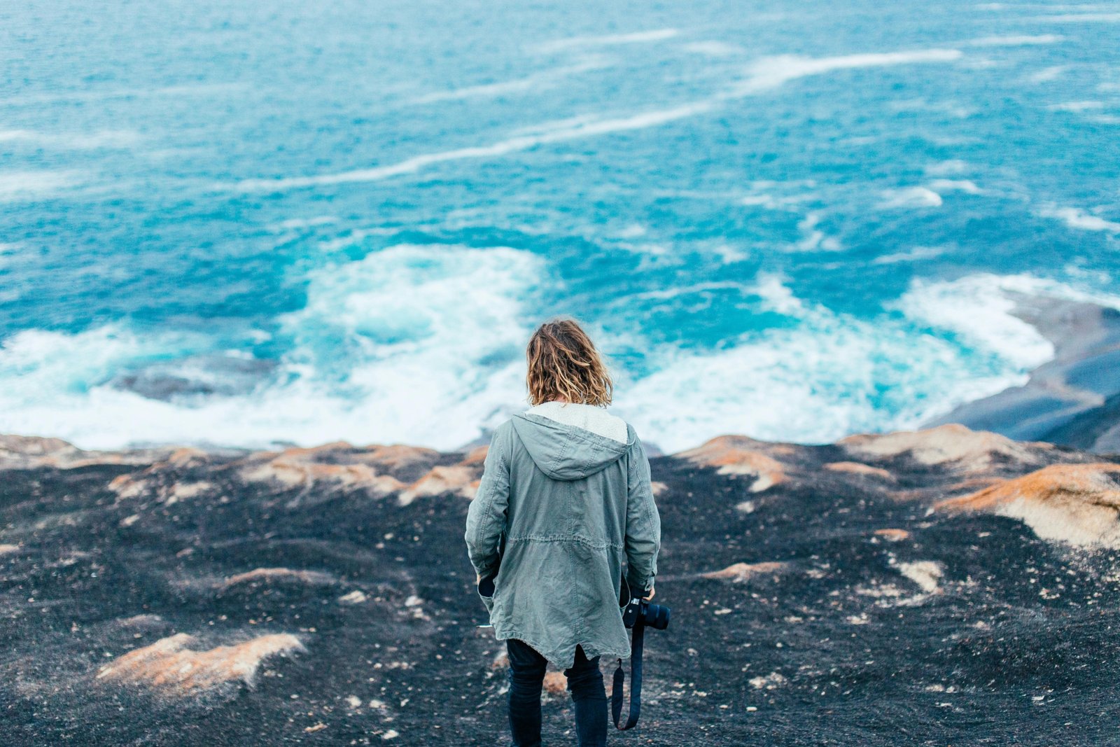 Confident woman on a solo travel adventure in a beautiful natural landscape, representing empowerment and freedom for female travelers.