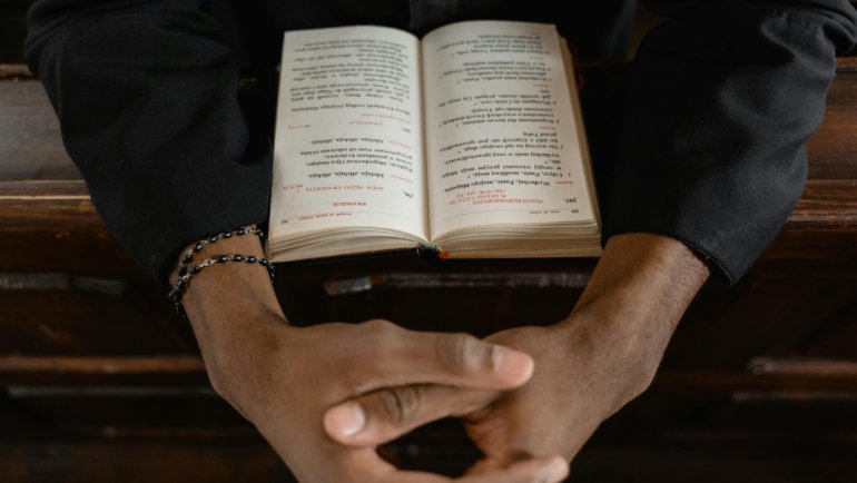 Christian prayer for safe travels, featuring hands clasped in prayer with a travel-related background, symbolizing divine protection and peace for journeys.