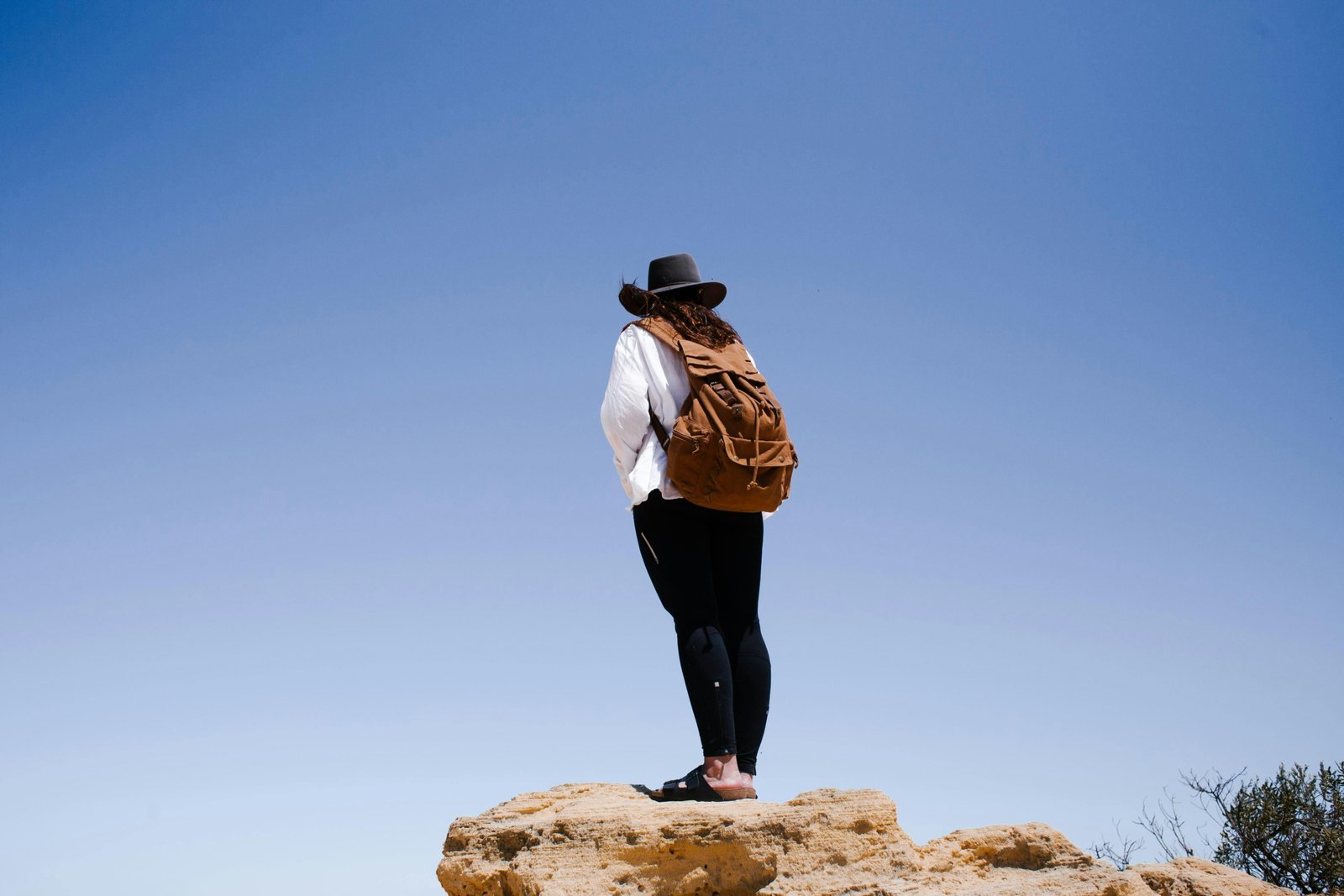 Happy traveler with a durable and comfortable rucksack in a beautiful landscape, illustrating the best gear for hassle-free adventure travel and long journeys.