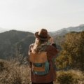 Traveler with a comfortable, carry-on compliant travel backpack exploring a vibrant city street or scenic outdoor trail, ideal for various adventures.