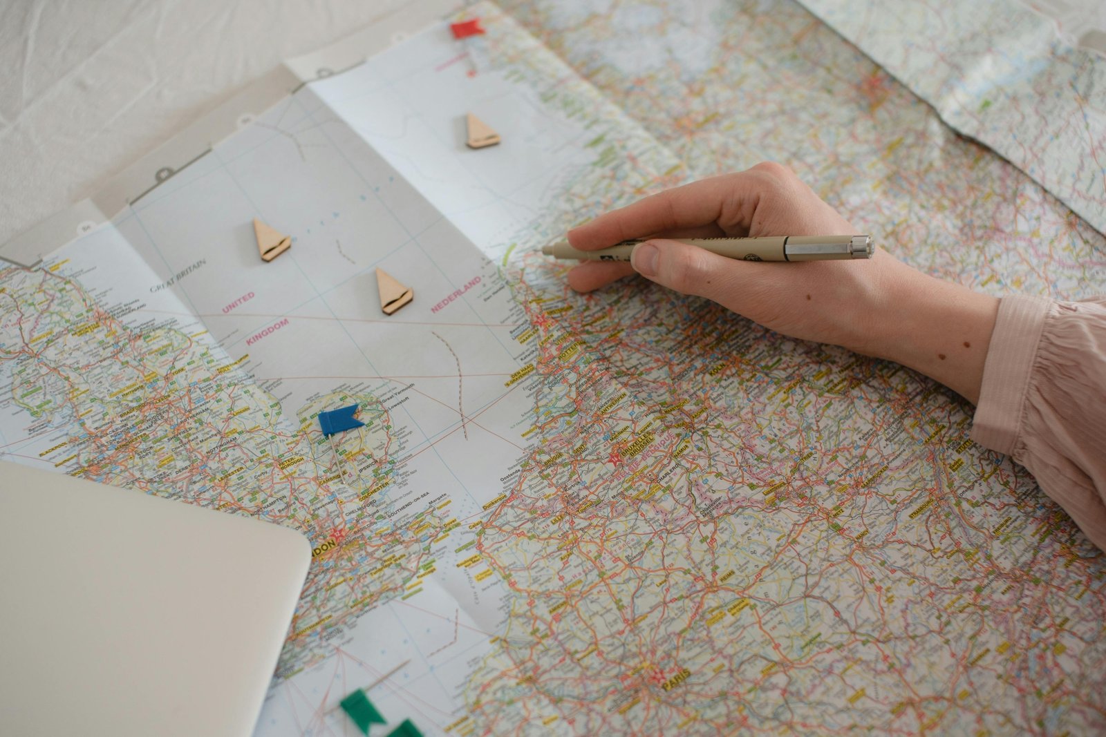 Person meticulously planning a detailed travel itinerary for a successful Schengen visa application to Europe, with a map, passport, and booking documents on a table.