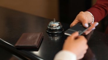 Happy person using a laptop to find and book discounted hotel deals online, symbolizing smart budget travel planning and significant savings on accommodation.