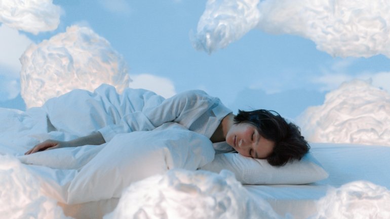 A relaxed traveler sleeping soundly on a long flight with a comfortable U-shaped memory foam travel pillow providing excellent neck support, preventing stiffness and promoting well-being for their journey.