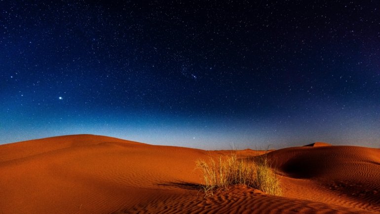 Breathtaking Milky Way over iconic orange dunes in Morocco's Sahara desert, illustrating a magical and unforgettable journey.