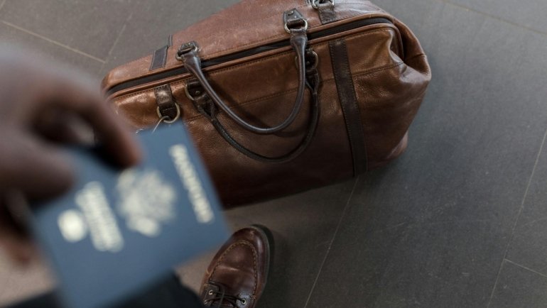 Elegant travel-sized perfume bottle with a passport and world map, symbolizing a globetrotter's essential fragrance for creating lasting travel memories.